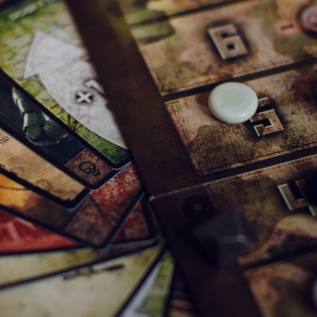 Person using a pen to cross a task off a productivity paper card.